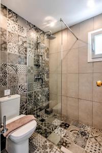 a bathroom with a toilet and a glass shower at Anamar Santorini in Monolithos