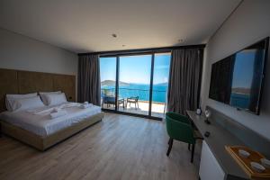 a bedroom with a bed and a desk with a view of the ocean at Apart-Hotel Lili2 in Sarandë