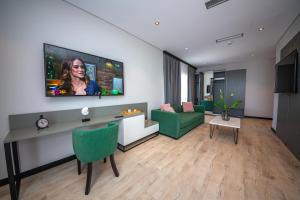 a living room with a television on a wall at Apart-Hotel Lili2 in Sarandë