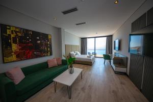 a living room with a green couch and a television at Apart-Hotel Lili2 in Sarandë