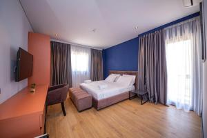 a bedroom with a bed and a desk and a television at Apart-Hotel Lili2 in Sarandë