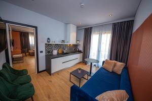 a living room with a blue couch and a kitchen at Apart-Hotel Lili2 in Sarandë