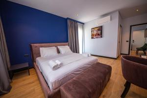 a bedroom with a large bed and a couch at Apart-Hotel Lili2 in Sarandë