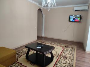 uma sala de estar com uma mesa e uma televisão na parede em 3-х ком квартира под ключ, Гагра em Gagra