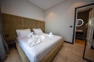 a bedroom with a white bed with towels on it at Apart-Hotel Lili2 in Sarandë