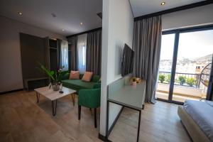 a living room with a green couch and a table at Apart-Hotel Lili2 in Sarandë