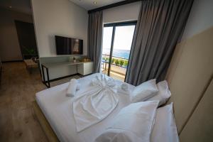 a bedroom with a white bed with a view of the ocean at Apart-Hotel Lili2 in Sarandë