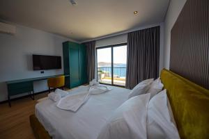 a hotel room with a bed with a large window at Apart-Hotel Lili2 in Sarandë