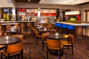 a restaurant with tables and chairs and a bar at Courtyard by Marriott Little Rock West in Little Rock