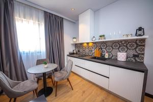 a kitchen with a counter and a table and a table at Apart-Hotel Lili2 in Sarandë