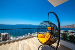 a swing on a balcony with a view of the ocean at Apart-Hotel Lili2 in Sarandë