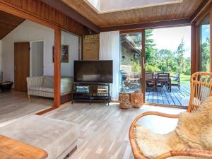 a living room with a television and a patio at 5 person holiday home in V ggerl se in Marielyst