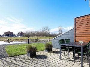 a patio with a table and chairs and a pond at 4 person holiday home in Bogense in Bogense