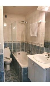 ein Badezimmer mit einem WC, einer Badewanne und einem Waschbecken in der Unterkunft Appartement avec piscine, 100m plage et hypercentre in Cabourg