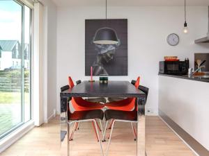 a dining room with a black table and red chairs at 6 person holiday home in V ggerl se in Marielyst