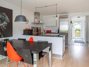 a kitchen and dining room with a black table and orange chairs at 6 person holiday home in V ggerl se in Marielyst