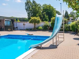 een blauwe glijbaan naast een zwembad bij Apartment Glesborg CVI in Glesborg