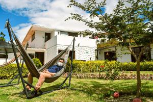 un hombre sentado en una hamaca en un patio en Posada Tierra Viva en Villa de Leyva
