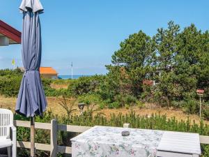 a blue umbrella sitting next to a white table with at 6 person holiday home in Glesborg in Glesborg
