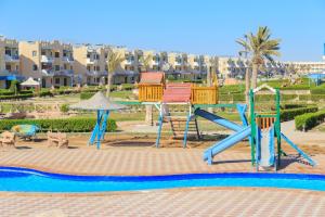 un parque infantil en un complejo con piscina en 2 bedroom challet with private garden at Riviera beach resort Ras Sudr,Families only en Ras Sedr