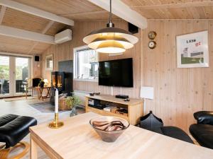 NordostにあるThree-Bedroom Holiday home in Sæby 4のリビングルーム(テレビ、テーブル、椅子付)