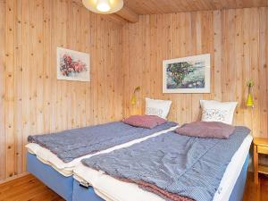 1 dormitorio con 2 camas en una pared de madera en Three-Bedroom Holiday home in Sæby 4, en Nordost