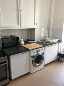 a kitchen with a washing machine and a microwave at La Promenade House in Nice