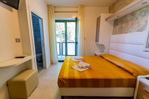 a bedroom with a bed with towels on it at Hotel Monica in Riccione +55 photos