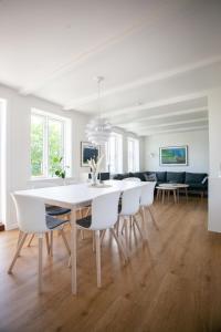 uma sala de jantar branca com uma mesa e cadeiras brancas em Luxurious House in Downtown Tórshavn em Tórshavn