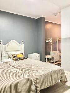 a bedroom with a white bed with a blue wall at NOW Bastidor Jovial in Lisbon