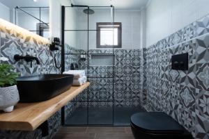 uma casa de banho com um lavatório preto e um chuveiro em Monemvasia Green Apartments em Monemvasia