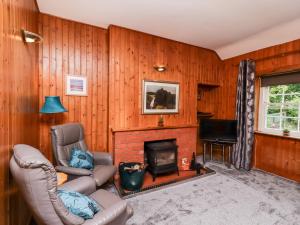 salon z kanapą i kominkiem w obiekcie Rose Cottage w mieście Stranraer