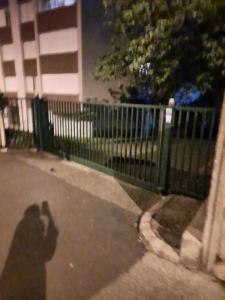 una sombra de una persona tomando una foto de una valla en Grand appartement fonctionnel et calme sur lyon8 a 2 pas du metro, en Lyon