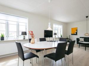 ein weißes Esszimmer mit einem Tisch und Stühlen in der Unterkunft 6 person holiday home in L kken in Løkken