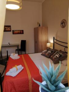 Un dormitorio con una cama con toallas y una planta en b & b Jasmine, en Santa Teresa di Riva