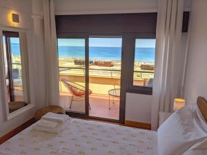 a bedroom with a bed and a view of the ocean at Seasun Vacation Rentals - OCEAN in Monte Gordo