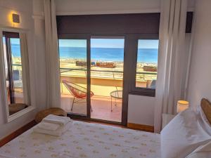 Un dormitorio con una cama y vista al mar. en Seasun Vacation Rentals - OCEAN, en Monte Gordo