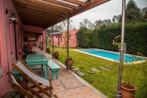 a patio with a table and a swimming pool at Como Entonces Posada in Uribelarrea