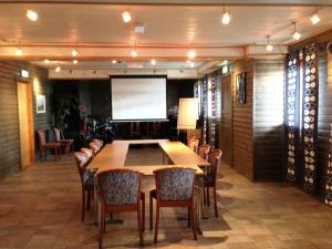 Kaikanten Rorbuer - Røst في روست: قاعة اجتماعات مع طاولة وكراسي وشاشة عرض