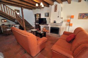 a living room with two chairs and a fireplace at La Fuente de Pavia in Caballar