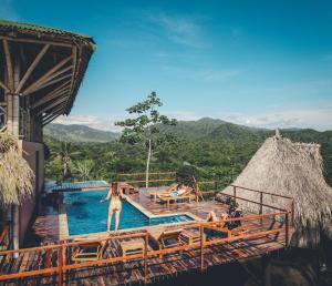 a pool at a resort with people in the water at The Journey Hostel in Los Naranjos