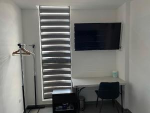 una stanza con una scrivania e una televisione su una parete di Departamento en Edificio El Semillero a Monterrey