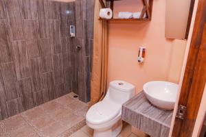 a bathroom with a toilet and a sink and a shower at Hotel Campestre Arenal in Fortuna +47 photos