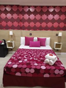 sypialnia z fioletowym łóżkiem z różowymi kwiatami na ścianie w obiekcie Hostal Inn Madrid w Madrycie