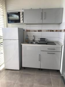 樂迪亞曼特的住宿－La Marinotel，白色的厨房配有水槽和冰箱