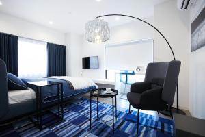 - une chambre avec un lit et une chaise dans l'établissement Designers Hotel Siesta, à Tokyo