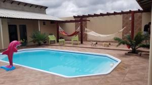 a swimming pool in a backyard with a hammock at Hotel Boutique Airla Seu Hotel em Casa in Boa Vista