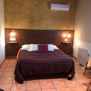 um quarto com uma cama grande e duas luzes na parede em HOTEL FAMILIAR BAGA em Bagá