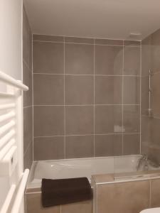a bathroom with a bath tub with a black towel at Appartement Grabels 2 à 4 personnes in Grabels