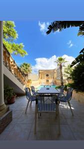 a patio with a table and chairs and a building at Villa Palma in Sannat